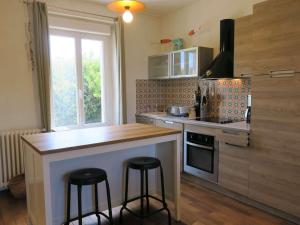 eine Küche mit Theke und zwei Barhockern in der Unterkunft Maison de charme avec jardin, terrasse et WIFI, à 600m de la mer à Pleumeur-Bodou - FR-1-368-294 in Pleumeur-Bodou + 13 Fotos