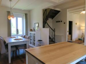 eine Küche und ein Esszimmer mit einem Tisch und einem Kühlschrank in der Unterkunft Maison de charme avec jardin, terrasse et WIFI, à 600m de la mer à Pleumeur-Bodou - FR-1-368-294 in Pleumeur-Bodou