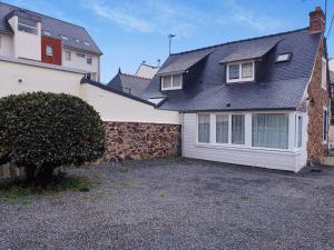 ein Haus mit einer Steinmauer und einer Garage in der Unterkunft Maison à Perros-Guirec avec WIFI, proche centre-ville et plage, cour fermée, parking privé - FR-1-368-324 in Perros-Guirec