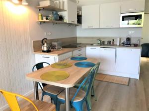 a kitchen with a table and chairs in a kitchen at Appartement Perros-Guirec, 2 pièces, 4 personnes - FR-1-368-341 in Perros-Guirec