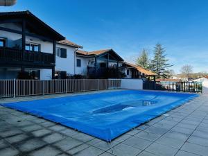 una piscina con telone blu di fronte a una casa di Appartement Cambo-les-Bains, 2 pièces, 2 personnes - FR-1-495-4 a Cambo-les-Bains
