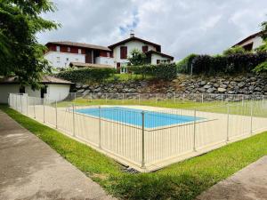 a fence around a swimming pool in a yard at Appartement Cambo-les-Bains, 2 pièces, 2 personnes - FR-1-495-59 in Cambo-les-Bains