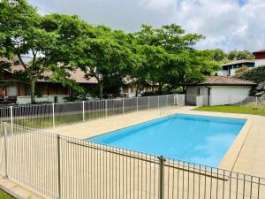 a large blue swimming pool next to a fence at Appartement Cambo-les-Bains, 2 pièces, 2 personnes - FR-1-495-59 in Cambo-les-Bains