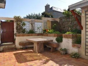 une terrasse en pierre avec un banc et une clôture dans l'établissement Appartement avec Terrasse, WIFI, Animaux admis, Parking à Trégastel - FR-1-368-209, à Trégastel