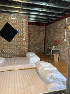Cette chambre comprend 2 lits et un parasol sur le mur. dans l'établissement Milk Milk Homestay, à Yên Minh