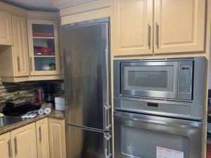 eine Küche mit einem Kühlschrank aus Edelstahl und einer Mikrowelle in der Unterkunft Guest House Room No 03 in Mississauga