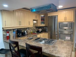a kitchen with stainless steel appliances and wooden cabinets at Guest House Room No 03 in Mississauga