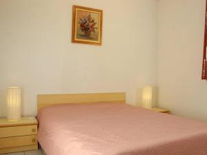sypialnia z różowym łóżkiem i 2 szafkami nocnymi w obiekcie Charmante maison avec piscine, 6 couchages, proche plage - Saint-Denis-d’Oléron - FR-1-246A-154 w mieście Saint-Denis-dʼOléron