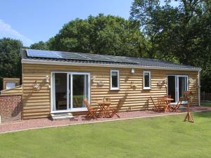 a log cabin with chairs and tables in a yard at Squirrels Drey in North Walsham