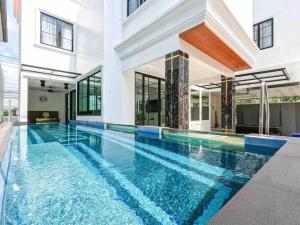 ein Swimmingpool mitten in einem Haus in der Unterkunft Pattaya Villa w/bathtub - Exquisite Pool Villa I in Nong Prue