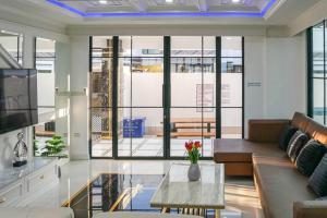 ein Wohnzimmer mit einer Couch und einem Glastisch in der Unterkunft Pattaya Villa w/bathtub - Exquisite Pool Villa I in Nong Prue