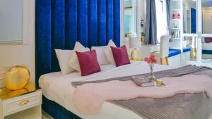 ein Schlafzimmer mit einem großen weißen Bett mit lila Kissen in der Unterkunft Pattaya Villa w/bathtub - Exquisite Pool Villa I in Nong Prue + 4 Fotos