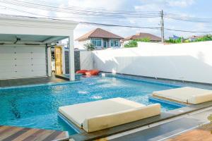 a swimming pool with two beds in a house at Exquisite Pool Villa J - Pattaya Pool Villa in Pattaya South