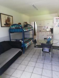 ein Wohnzimmer mit Etagenbetten und einem Glastisch in der Unterkunft Edward Cabana in Margate