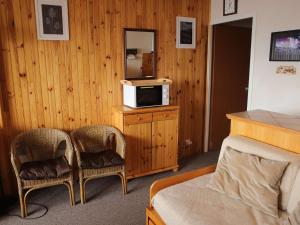 a room with a bed and two chairs and a microwave at Appartement Auris, 2 pièces, 6 personnes - FR-1-297-11 in Auris