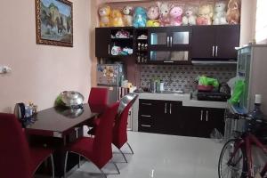 cocina con mesa y sillas rojas en una habitación en Cheerfull residential home - Dillair Home Stay, en Talang Kelapa