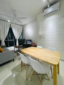 uma sala de jantar com uma mesa de madeira e cadeiras brancas em Wallaway2stay Gravit8 Klang 2Room em Klang