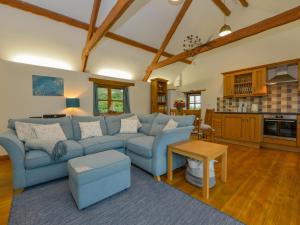 a living room with a blue couch and a table at Hook Cottage in Looe