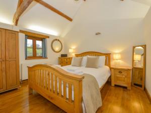 a bedroom with a wooden bed and a mirror at Hook Cottage in Looe