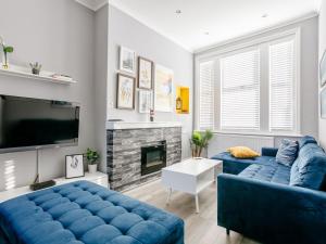 a living room with blue couches and a fireplace at Relax In Ramsgate in Ramsgate