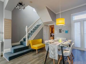 uma sala de jantar com uma mesa e uma escada em Relax In Ramsgate em Ramsgate