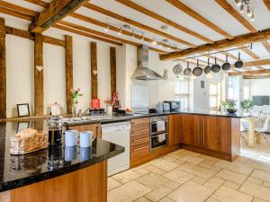 a large kitchen with wooden cabinets and a counter top at Laurel Barn in Ashwellthorpe