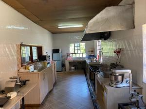 a large kitchen with a stove and a sink at Easy Sleep Guesthouse in Kitale