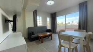 a living room with a couch and a table and chairs at benal beach 81 in Benalmádena