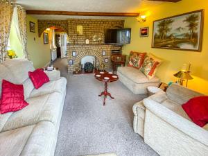 uma sala de estar com dois sofás e uma lareira em Queensland Cottage em St Margarets at Cliff