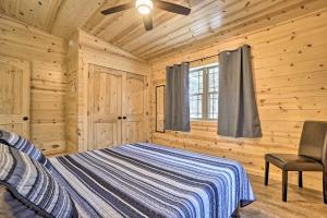 una camera con un letto in una baita di tronchi di Quiet Pines Cabin with Hot Tub and Fishing Pond! a Logan