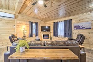 un soggiorno con divano in pelle e tavolo di Quiet Pines Cabin with Hot Tub and Fishing Pond! a Logan