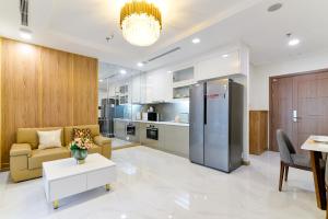 a kitchen and living room with a couch and a refrigerator at Landmark 81 Vinhomes Central Park Luxury Apartment in Ho Chi Minh City
