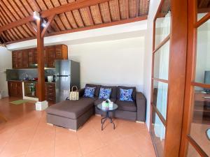 a living room with a couch and a table at Villa Mudha 3 Sanur in Sanur