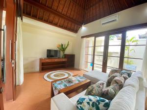 a living room with a couch and a tv at Villa Mudha 3 Sanur in Sanur