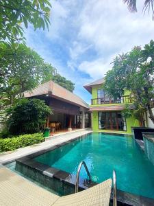 a swimming pool in front of a house at Villa Mudha 3 Sanur in Sanur