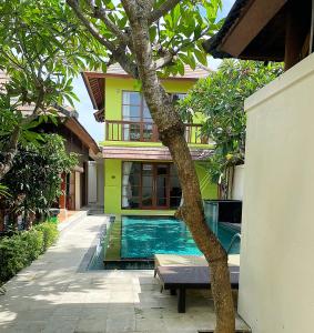 a house with a swimming pool in front of a house at Villa Mudha 3 Sanur in Sanur