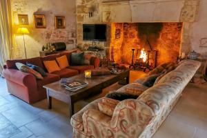 a living room with two couches and a fireplace at Charming 14th Century Village Chateau with gardens and outdoor pool in Celles