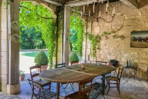a dining room with a wooden table and chairs at Charming 14th Century Village Chateau with gardens and outdoor pool in Celles