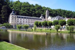a large building next to a body of water at Charming 14th Century Village Chateau with gardens and outdoor pool in Celles