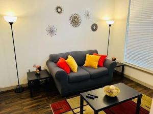 a living room with a gray couch with colorful pillows at Apto 1 Bed - Kitchen - FREE Parking in Houston