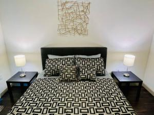 a bedroom with a black and white bed and two lamps at Apto 1 Bed - Kitchen - FREE Parking in Houston