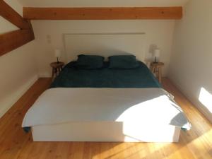 um quarto com uma cama grande e lençóis verdes em Gîte l'olivier em Mézoargues