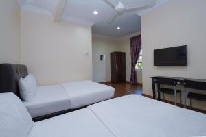 Super OYO 90009 Bangi Sri Minang Guesthouse في بانغي: غرفة فندقية بسريرين وتلفزيون بشاشة مسطحة