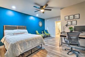 ein Schlafzimmer mit einer blauen Wand, einem Bett und einem Schreibtisch in der Unterkunft Stonecrest Getaway about 18 Mi to Atlanta! in Lithonia