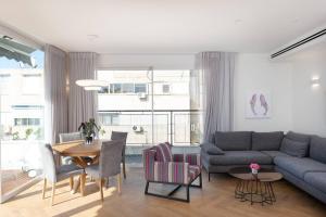 a living room with a couch and a table at Decoreted 2 bed. Penthouse with a sun terrace in Tel Aviv