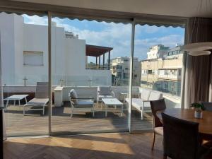 - Balcón con mesa y sillas en un edificio en Decoreted 2 bed. Penthouse with a sun terrace, en Tel Aviv