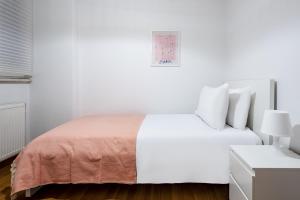 una camera da letto bianca con un letto bianco e una coperta rosa di Magnificent a Istanbul