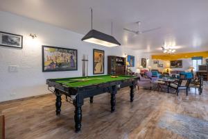 a living room with a pool table in it at StayVista at The Hideout with private outdoor pool in Kurukshetra