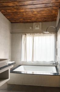 a bath tub in a room with a window at The Sylvan Retreat in Dehradun