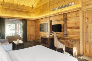 a bedroom with a bed and a tv in a room at The Sylvan Retreat in Dehradun
